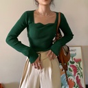 كنزة نسائية بياقة مربعة وحواف متموجة.