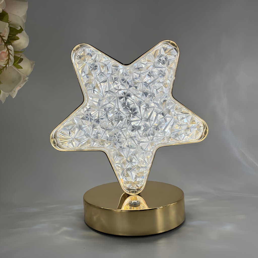 A luxurious and elegant night table lamp with a star and moon design, featuring touch control and rechargeable functionality for a warm and inviting ambiance