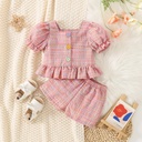 Elegant summer outfit for girls featuring a plaid-patterned top and stylish shorts with a modern, feminine touch — perfect for a comfortable and chic everyday look