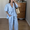 Elegant solid-color set featuring a V-neck puff-sleeve top with a waist tie, paired with matching trousers for a feminine and modern look