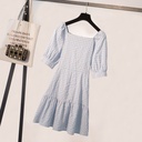 A stately dress featuring a plaid pattern inspired by French elegance