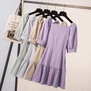 A stately dress featuring a plaid pattern inspired by French elegance